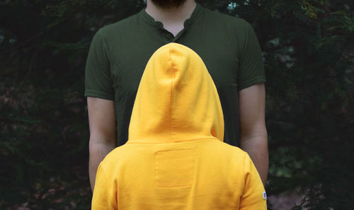 Rear view of man standing against yellow trees