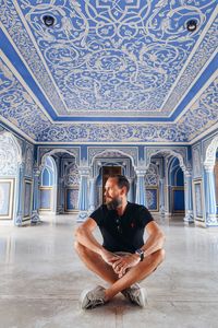 Young man sitting on floor in building