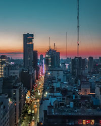 Illuminated cityscape against sky at dusk