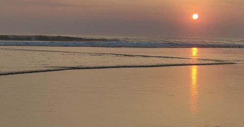 Scenic view of beach against sky during sunset