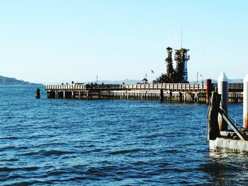 Pier in calm sea against clear sky