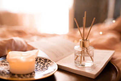 Close-up of home liquid diffuser and candle