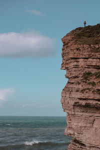 Rock formations on beach against sky