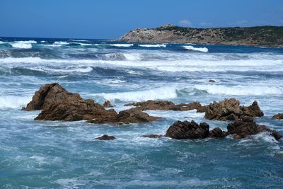 Scenic view of rocks in sea against sky