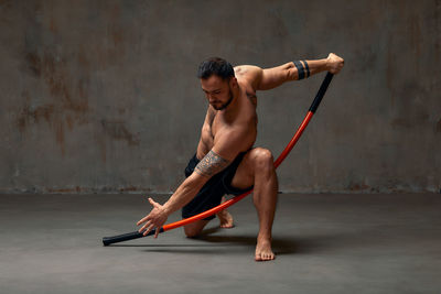 Man practicing with combat stick in gym