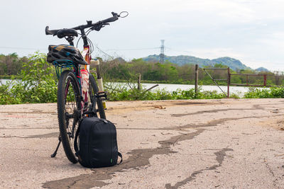 Bicycle parked on road against sky