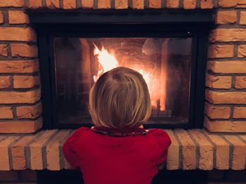 Rear view of boy in front of window