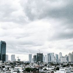 Modern cityscape against cloudy sky