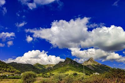 Panoramic view of landscape and mountains against blue sky