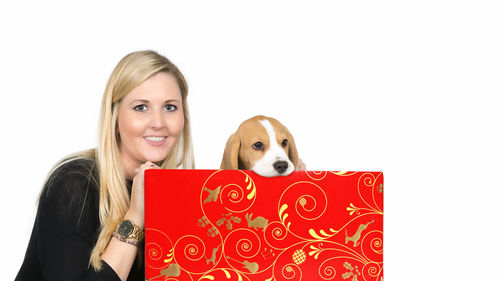 Portrait of woman with dog against white background
