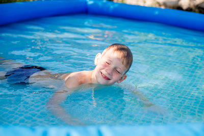 Portrait of happy boy swimming in pool