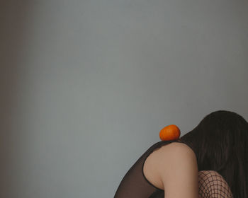 Sad woman in black lingerie ant fishnet tights with mandarins