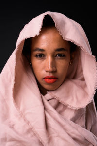 Portrait of beautiful young woman over black background