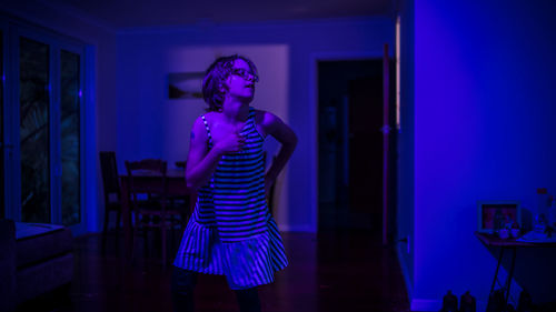 Young woman dancing at home during night