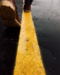 Low section of man standing on road