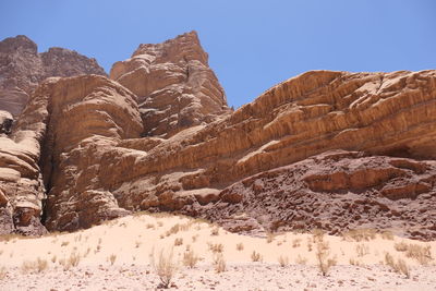 Rock formations in wadi rum on landscape against clear sky