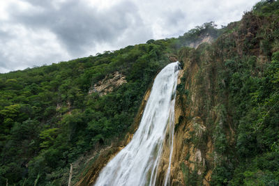 Scenic view of waterfall against sky