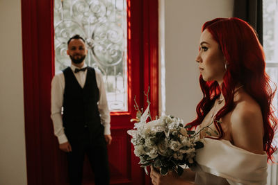 Young woman standing by red rose