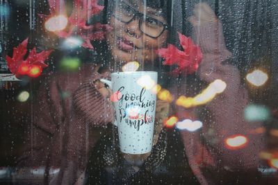 Portrait of woman with reflection on glass window