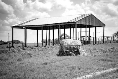 Old barn on field against sky