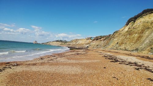 Scenic view of beach against blue sky