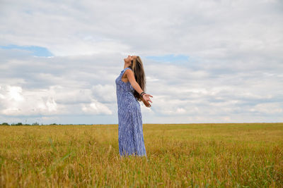 Rear view of woman standing on field