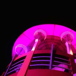 Low angle view of illuminated ferris wheel at night