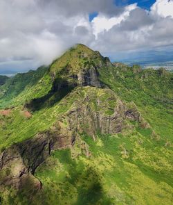 View of green landscape against cloudy sky