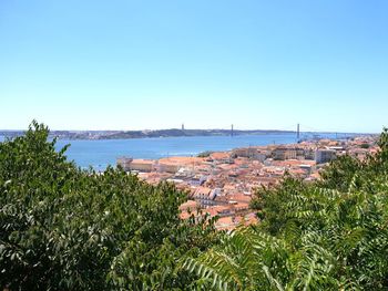 High angle view of sea and buildings against clear sky