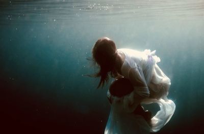 Woman wearing dress swimming in sea