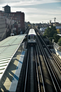 Railroad tracks in city against sky