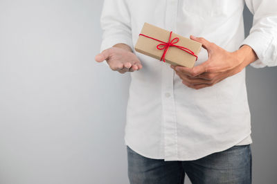 Midsection of man standing against white background