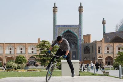 Full length of man and buildings against sky in city