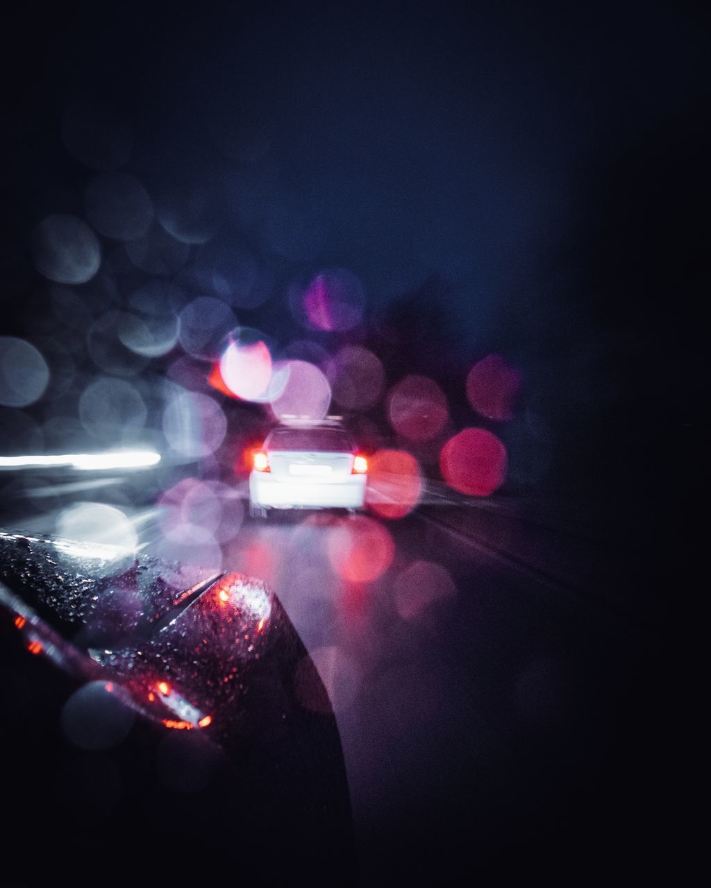 DEFOCUSED IMAGE OF ILLUMINATED CAR ON STREET