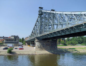 Bridge over river in city against clear sky
