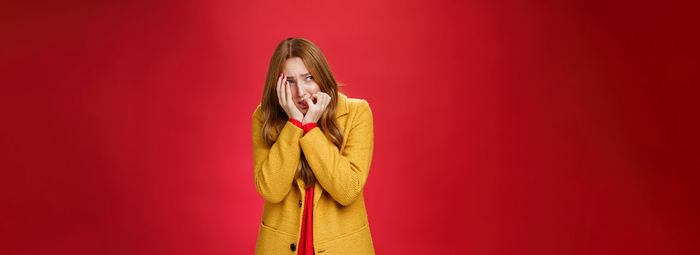 Low section of woman standing against yellow background