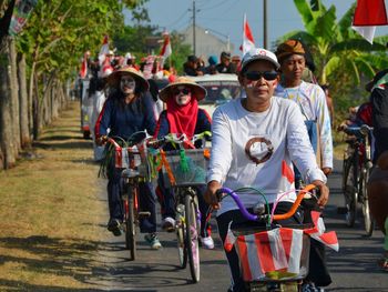 People with face paint riding bicycles