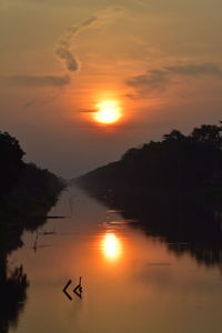 Scenic view of lake against orange sky