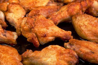 Many fried, sliced chicken wings, with crispy crust.