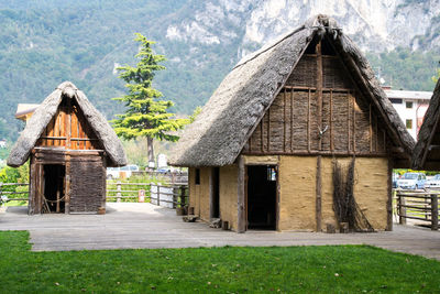 View of cottage by house against mountain