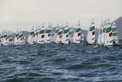 Panoramic view of people on sea against sky