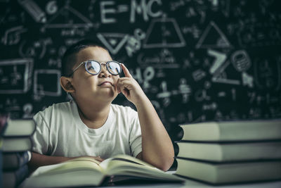 Portrait of boy sitting on book