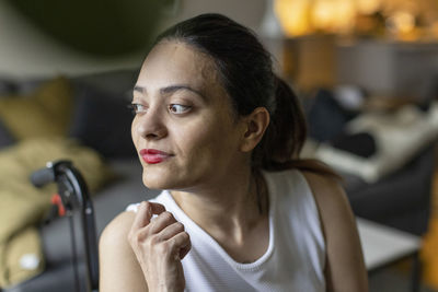 Thoughtful woman with paraplegia looking away at home