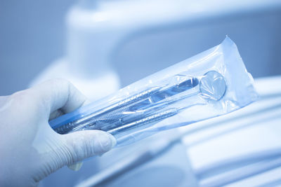 Cropped hand of dentist holding dental equipment in medical clinic