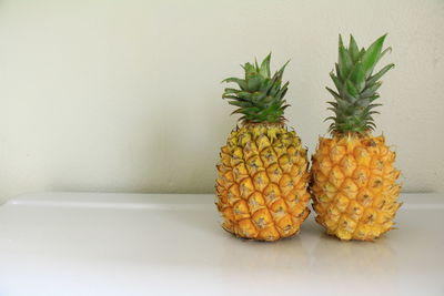 Close-up of orange fruits on table against wall