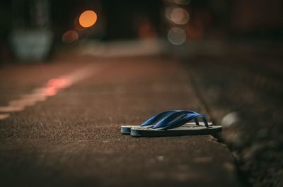 Close-up of shoes on street at night