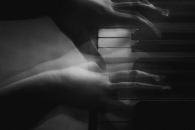 Close-up of hand playing piano