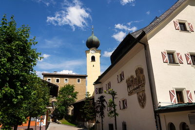 Low angle view of buildings and trees against sky