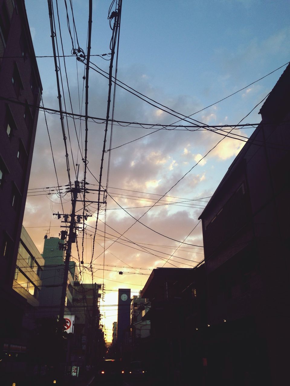 building exterior, architecture, built structure, power line, sunset, cable, city, electricity pylon, sky, low angle view, silhouette, electricity, power supply, connection, building, transportation, residential building, city life, residential structure, dusk