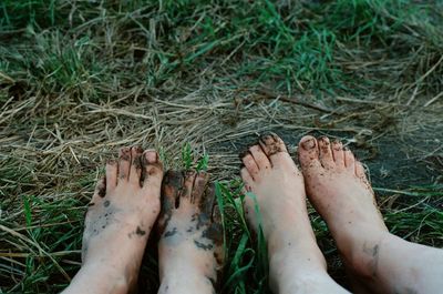Dirty feet of two women on grass